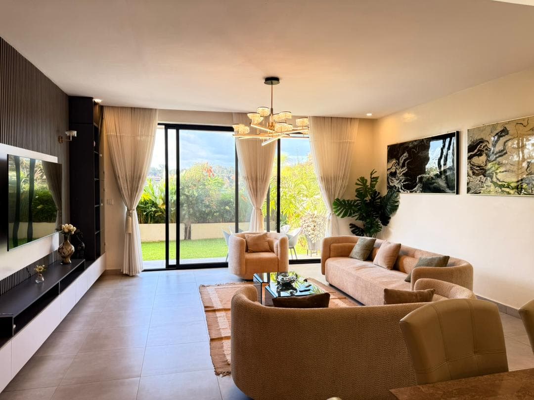 Living room feature TV wall with garden view through sliding doors